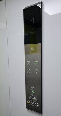 Bedienelemente des Aufzugs: Etagenanzeige oben, darunter Tasten für Notruf, darunter Tasten für die Etagenwahl sowie Tasten zum Öffnen und Schließen der Tür